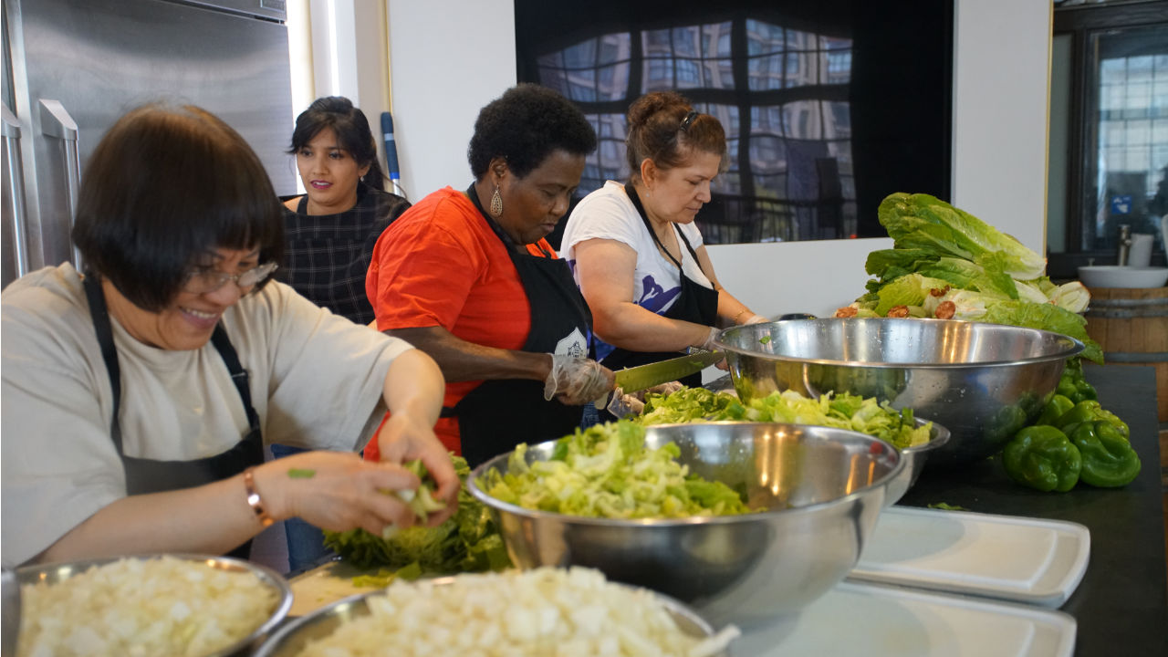 Four ladies working in a kitchen for volunteer catering services with St James Town