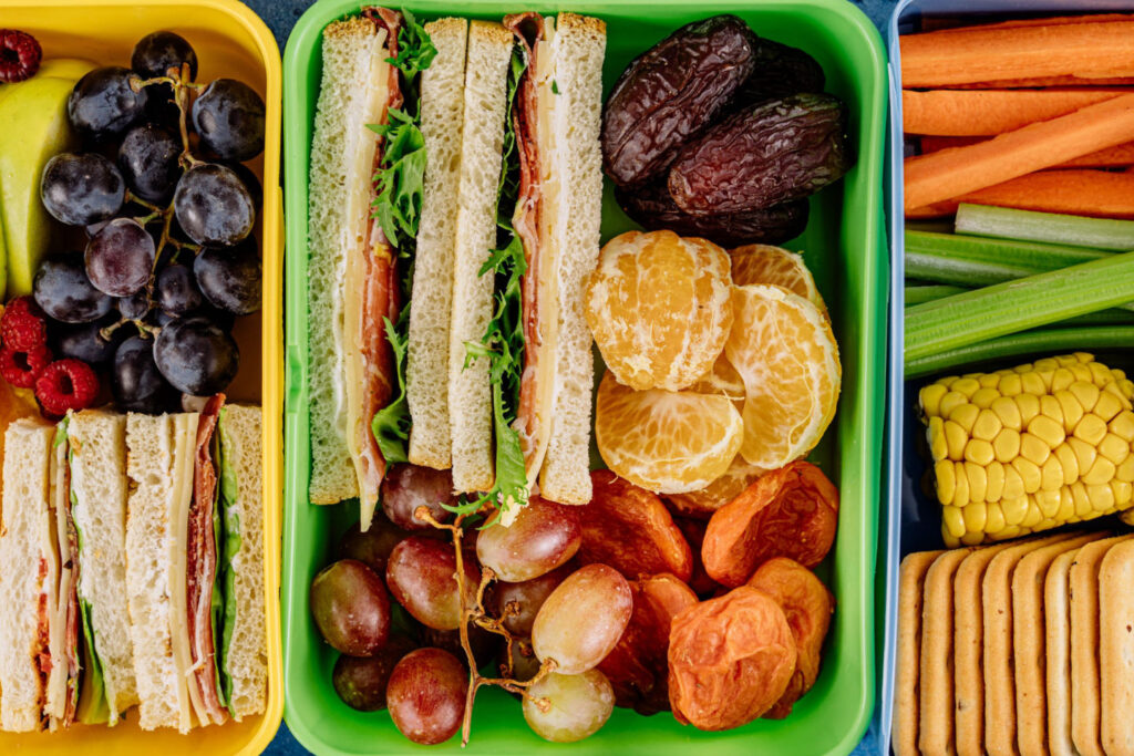 Vegetables and fruits with a sandwich in 3 boxes