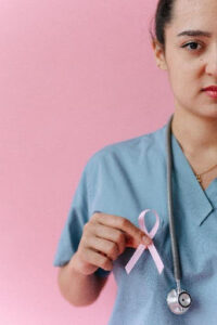 A nurse is holding a pink ribbon