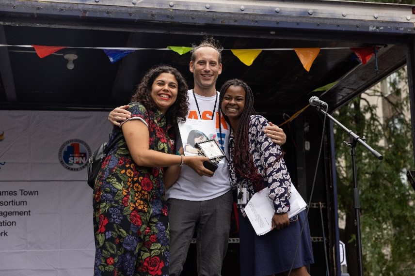 John Petrullo (Centre) receiving the award on behalf of Sanket Rane from Barbara Dos Santos (Left) and Tatyana Watts (Right)